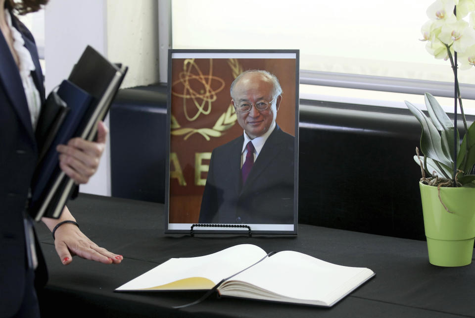 A book of condolence in front of a portrait photo of the Director General of the International Atomic Energy Agency, IAEA, Yukiya Amano from Japan is positioned in Vienna, Austria, Monday, July 22, 2019. The IAEA announced the death of the agency's Director General Yukiya Amano at the age of 72 years. (AP Photo/Ronald Zak)