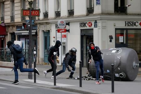 A hooded youth throws a bottle during clashes at a demonstration to protest the results of the first round of the presidential election in Paris, France, April 27, 2017. REUTERS/Gonzalo Fuentes