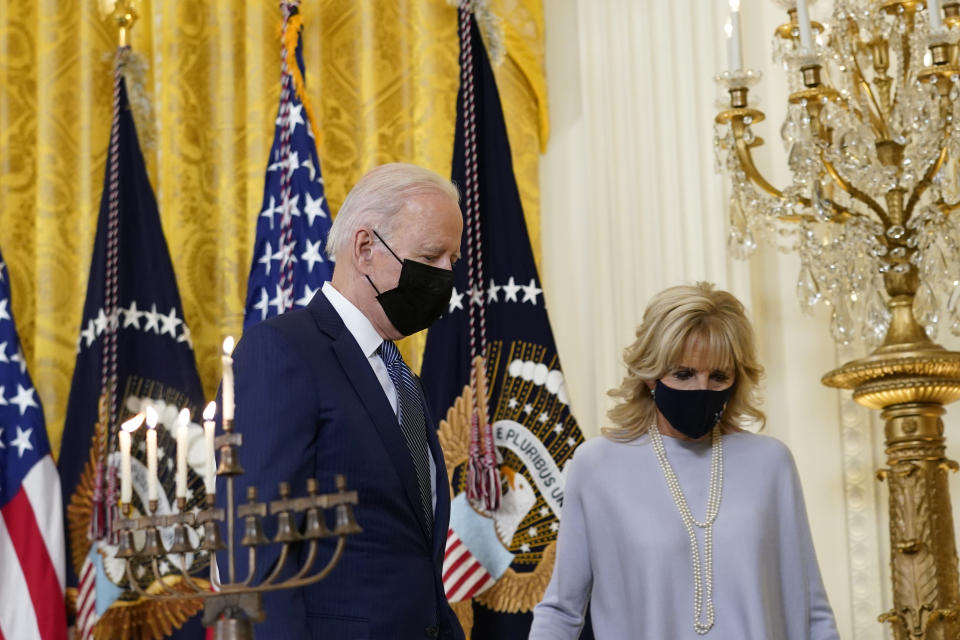 President Joe Biden and first lady Jill Biden walk past the lit menorah following an event in the East Room of the White House in Washington, to celebrate Hanukkah, Wednesday, Dec. 1, 2021. (AP Photo/Susan Walsh)