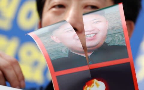 North Korean defector Park Sang-Hak holds a defaced portrait of North Korean leader Kim Jong-Un during a rally against the South Korean government's policy on North Korea - Credit: EPA/JEON HEON-KYUN
