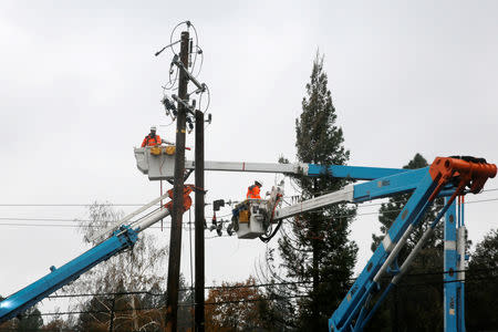 FILE PHOTO: PG&E crew work on power lines to repair damage caused by the Camp Fire in Paradise, California, U.S. November 21, 2018. REUTERS/Elijah Nouvelage/File Photo