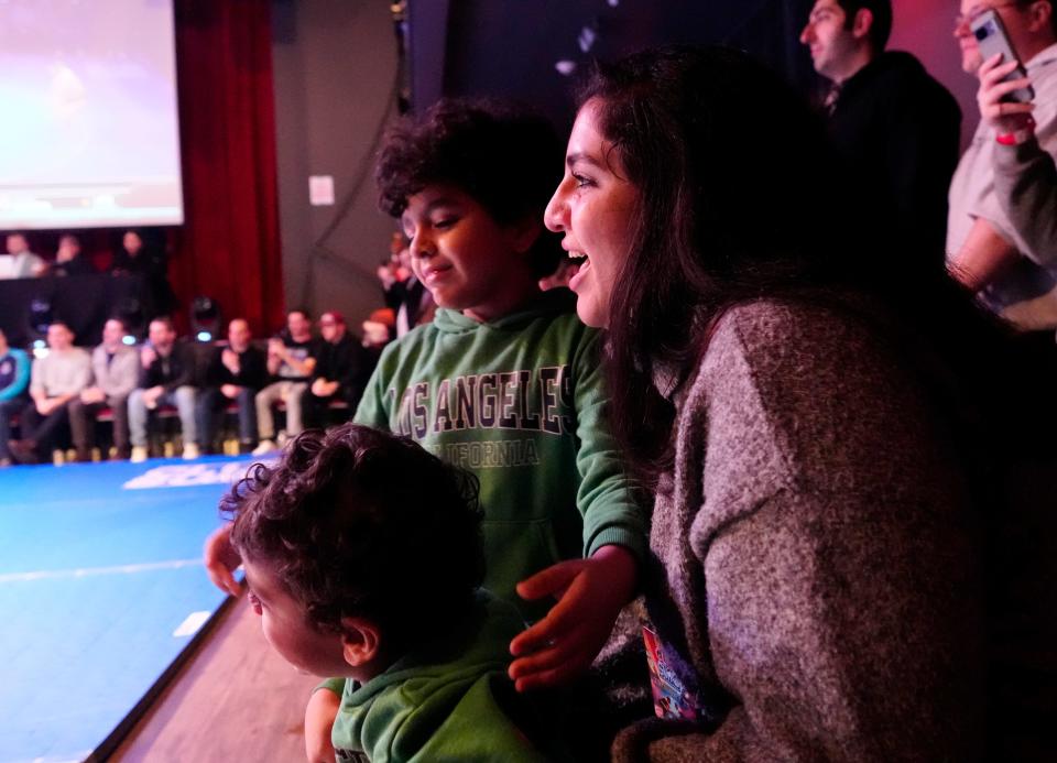Alaa Okasha, Shalan's wife, cheers with her three sons at the Jersey City event. The couple met in Japan, where she was a college student and he was, in his own words, "a legend."