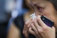 A Singaporean cries as she reads condolence messages at the entrance to the Istana presidential palace following the death of ex-premier Lee Kuan Yew in Singapore, on March 23, 2015