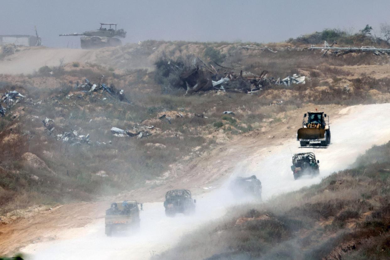 This picture taken from Israel’s southern border with the Gaza Strip shows Israeli military vehicles returning from the Palestinian territory on 24 April 2024, amid the ongoing conflict between Israel and the militant group Hamas (AFP via Getty Images)
