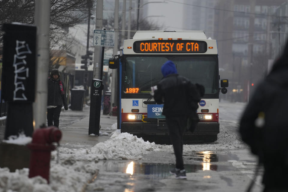 Migrants return to "warming" buses provided by the Chicago Transit Authority after receiving clothing and food donations from JPastor Jonathan de la O and volunteers with Starting Point Community Church Friday, Jan. 12, 2024, in Chicago. In the city's latest attempt to provide shelter to incoming migrants, several CTA buses were parked in the area of 800 South Desplaines Street to house people in cold winter weather. (AP Photo/Erin Hooley)