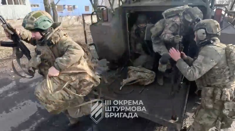 Soldados ucranianos salen de un vehículo militar en un lugar indicado como Avdiivka, región de Donetsk.