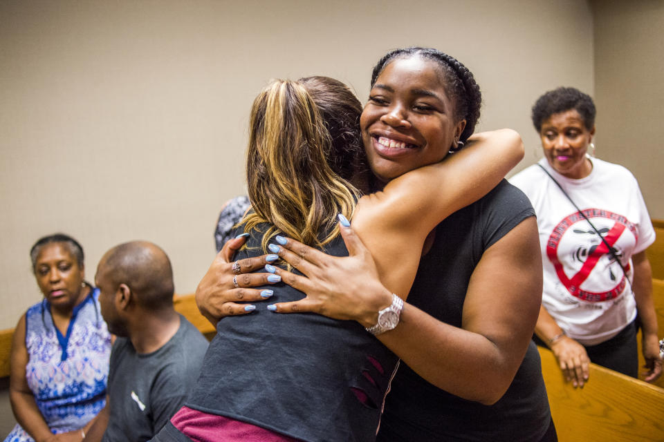 Flint resident Ariana Hawkins celebrates with Katrina Petri after Genesee District Judge David J. Goggins gave his decision during Nick Lyon's preliminary examination on Monday, Aug. 20, 2018 at Genesee District Court in Flint, Mich. Goggins ordered Lyons to stand trial for involuntary manslaughter in two deaths linked to Legionnaires' disease in the Flint area, the highest ranking official to stand trial as a result of the tainted water scandal. (Jake May/The Flint Journal via AP)