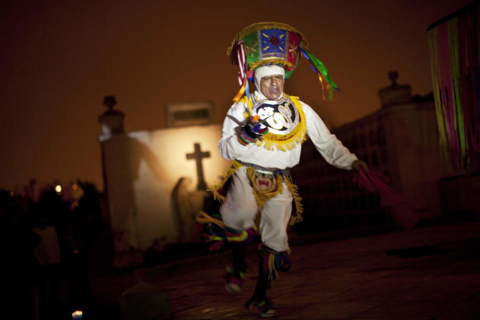 In this Dec. 6, 2012 photo, a performer dramatizes a historic event during a nighttime guided tour at the Presbitero Matias Maestro cemetery in Lima, Peru. Guides tell Peru's history through the tombs of presidents, prelates, poets, potentates and war heroes. (AP Photo/Rodrigo Abd)