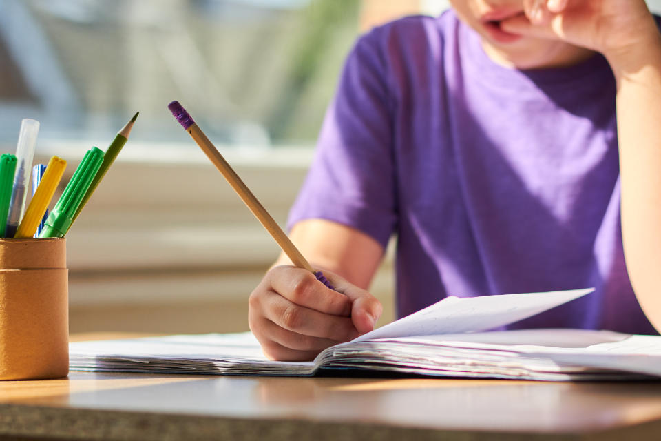 Young child sitting at a table learning and completing school work.