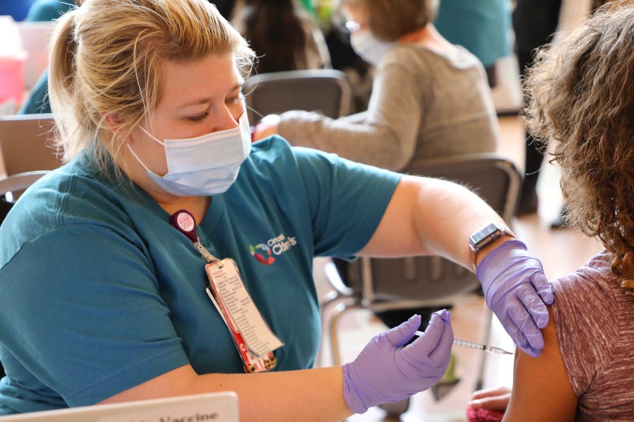 Stephanie Lightner, a Cincinnati Children's Hospital Medical Center registered nurse, vaccinates a child in December 2021.