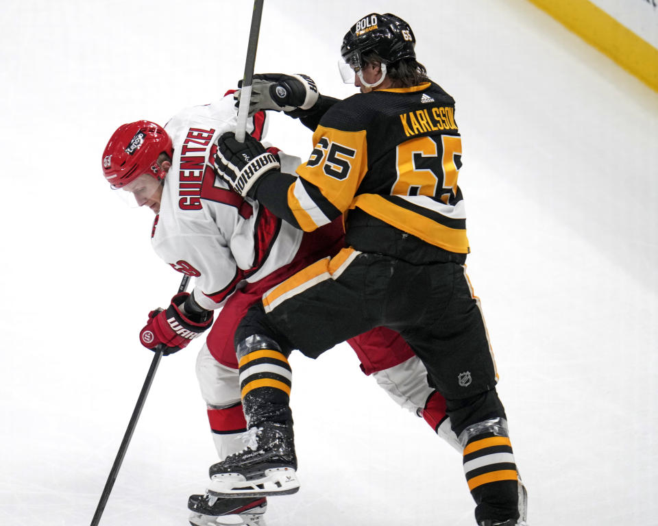 Carolina Hurricanes' Jake Guentzel (59) is defended by Pittsburgh Penguins' Erik Karlsson during the first period of an NHL hockey game in Pittsburgh, Tuesday, March 26, 2024. (AP Photo/Gene J. Puskar)