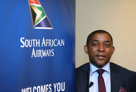 Vuyani Jarana, SAA Group CEO, poses for a photograph next to a South African Airways logo in Johannesburg