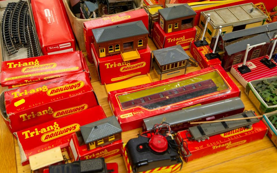 Boxes of vintage Tri-ang Railways toy train sets on display in an auction room