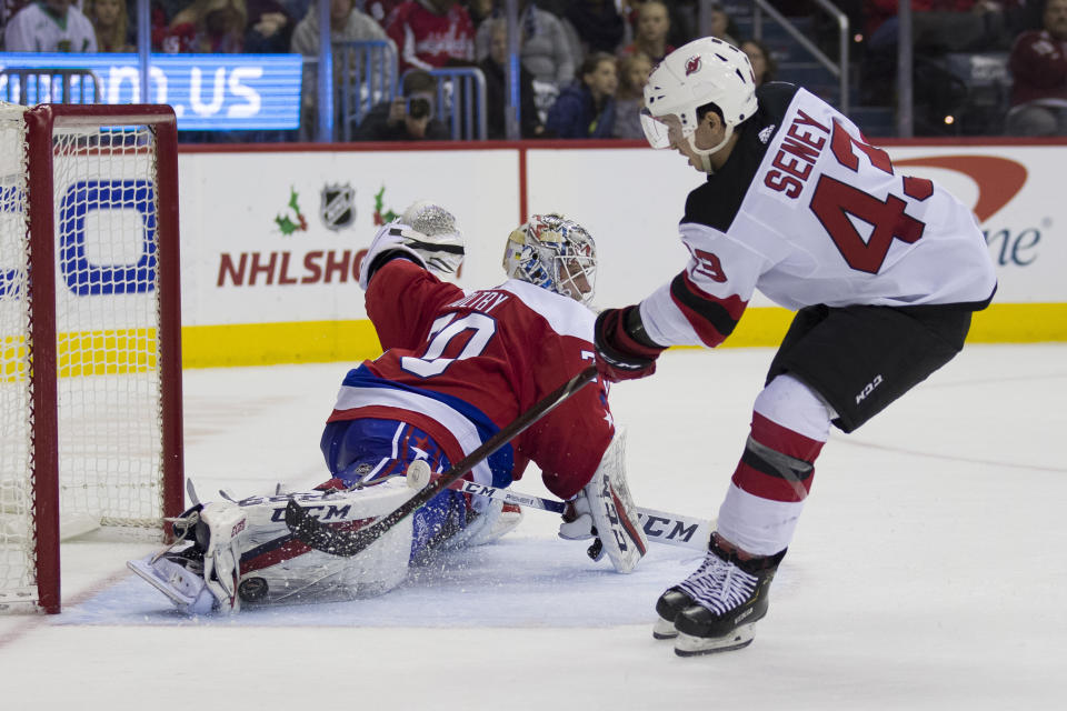 Washington Capitals goaltender Braden Holtby (70) blocks a shot by New Jersey Devils left wing Brett Seney (43) during the second period of an NHL hockey game Friday, Nov. 30, 2018, in Washington. (AP Photo/Alex Brandon)