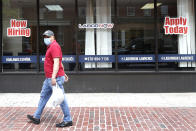 A man walks by a career center storefront, Friday, June 5, 2020, in Lawrence, Mass. The U.S. unemployment rate fell unexpectedly in May to 13.3% — still on par with what the nation witnessed during the Great Depression — as states loosened their coronavirus lockdowns and businesses began recalling workers. (AP Photo/Elise Amendola)