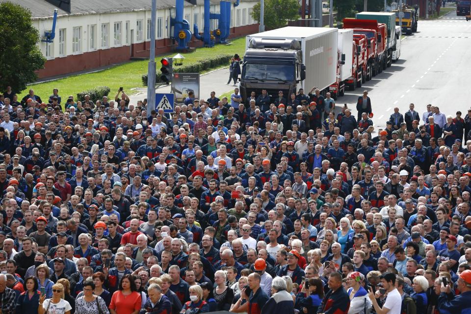 Workers listen to a speaker as they gather during a rally at the Minsk Automobile Plant in Minsk, Belarus, Friday, Aug. 14, 2020. Workers at the plant demanded a new election and called for the release of all those who were detained in a brutal police crackdown on demonstrators challenging the official results of Sunday's presidential vote. (AP Photo/Sergei Grits)