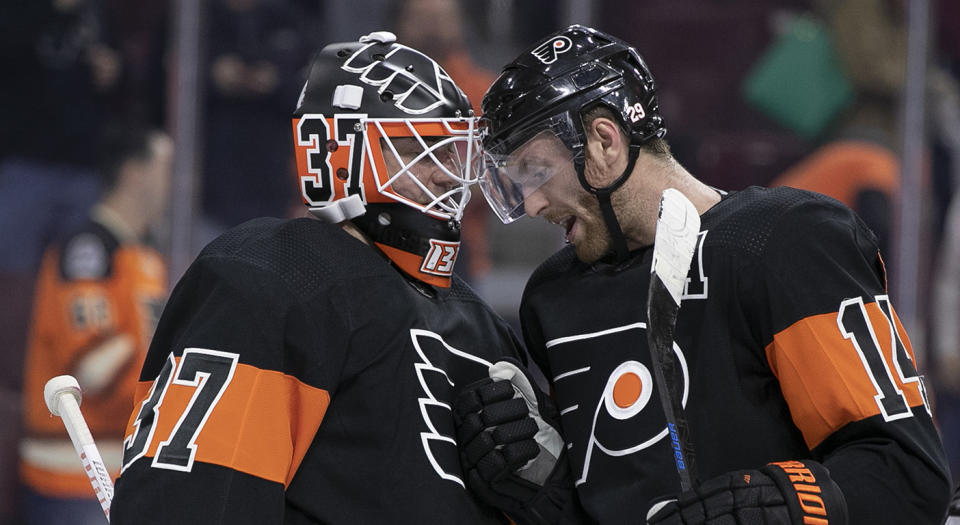 Philadelphia Flyers' Brian Elliott, left, celebrates the win with Sean Couturier, right, following the third period of an NHL hockey game against the Chicago Blackhawks, Saturday, Nov. 10, 2018, in Philadelphia. The Flyers won 4-0. (AP Photo/Chris Szagola)