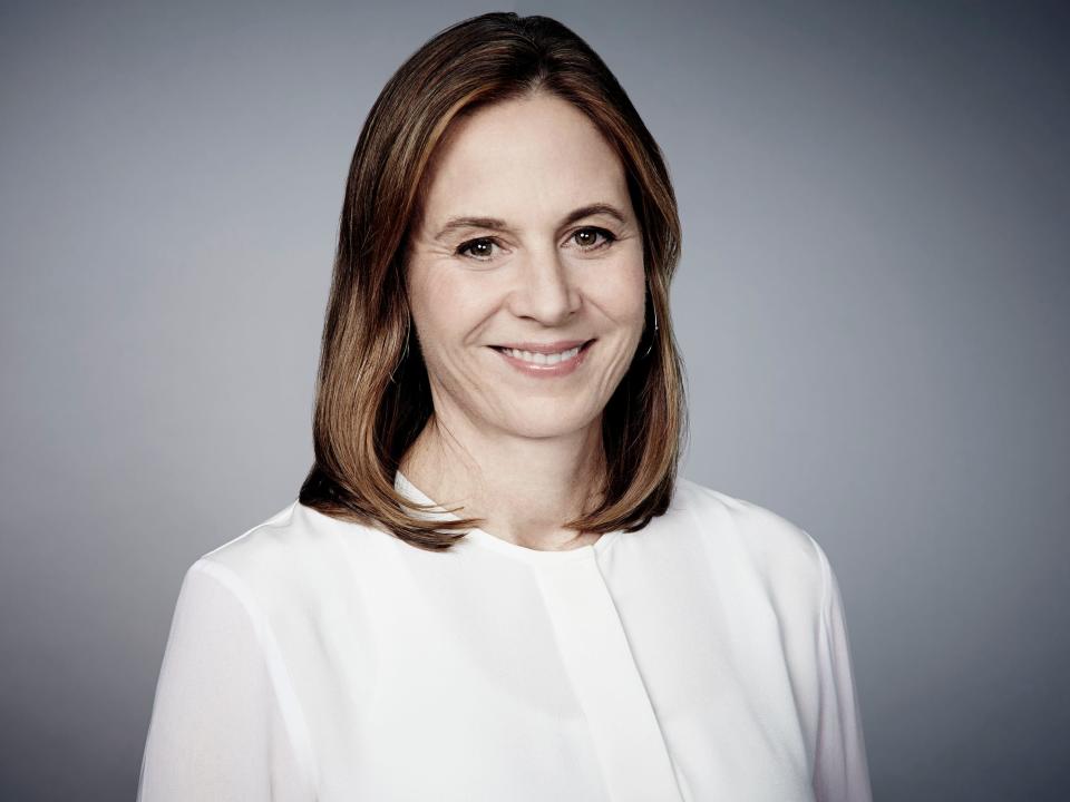 White woman in white shirt with shoulder length hair