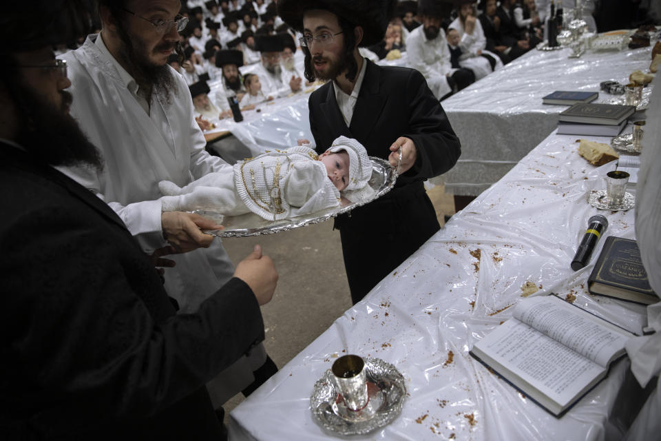 Yaakov Tabersky, right, presented his firstborn son, Yossef on a silver platter to Jewish priests from the Lelov Hassidic dynasty, during the "Pidyon Haben" ceremony in Beit Shemesh, Israel, Thursday, Sept. 16, 2021. The Pidyon Haben, or redemption of the firstborn son, is a Jewish ceremony hearkening back to the biblical exodus from Egypt. (AP Photo/Oded Balilty)