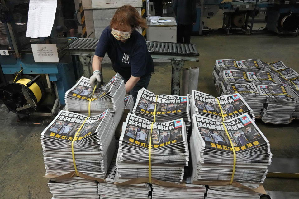 A worker packs copies of Apple Daily newspaper at the printing house in Hong Kong, early Friday, June 18, 2021. Five editors and executives at pro-democracy Apple Daily newspaper were arrested Thursday under Hong Kong's national security law, its stock was halted and police were searching its offices in moves raising concerns about the media's future in the city. (AP Photo/Kin Cheung)