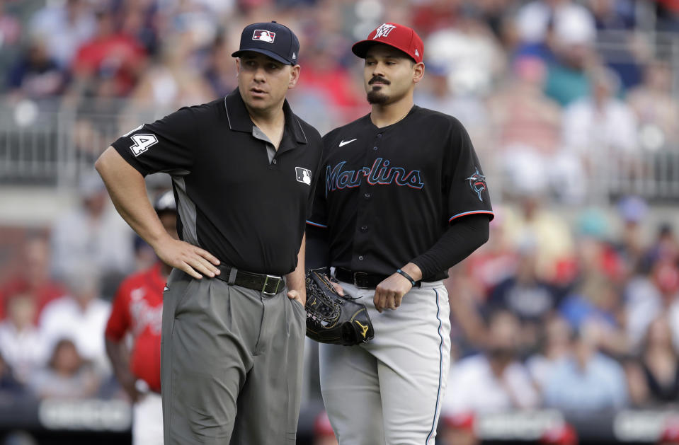 Miami Marlins pitcher Pablo Lopez, right, speaks with an umpire after hitting Atlanta Braves' Ronald Acuna Jr. with his first pitch in the first inning of a baseball game Friday, July 2, 2021, in Atlanta. (AP Photo/Ben Margot)