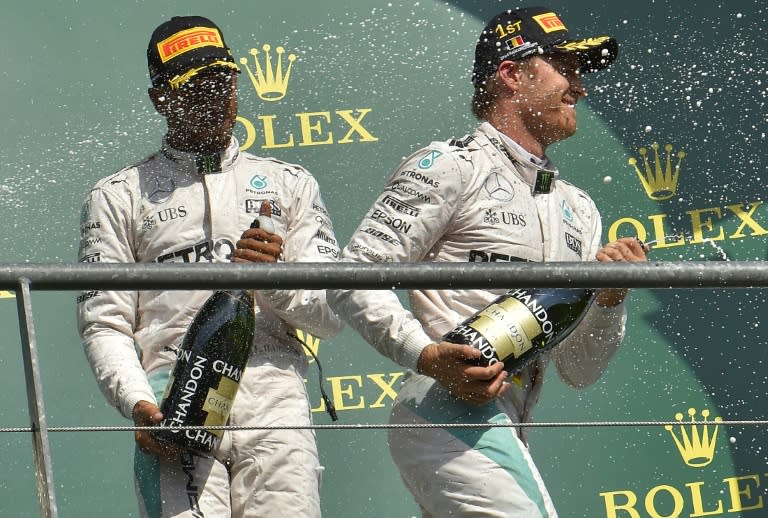 Mercedes driver Nico Rosberg (R) celebrates his victory alongside third placed teammate Lewis Hamilton at the Belgian Grand Prix in Spa on August 28, 2016