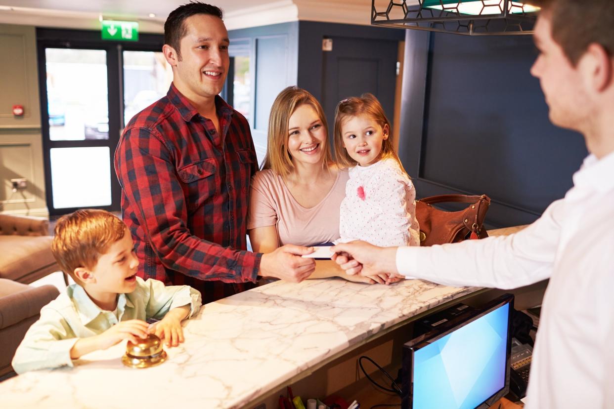 family checking in at hotel reception desk