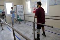 Abdelmawla Ibrahim, a Syrian amputee and physical therapist, passes a ball to a patient at Al-Bab centre for prosthetics in Al-Bab