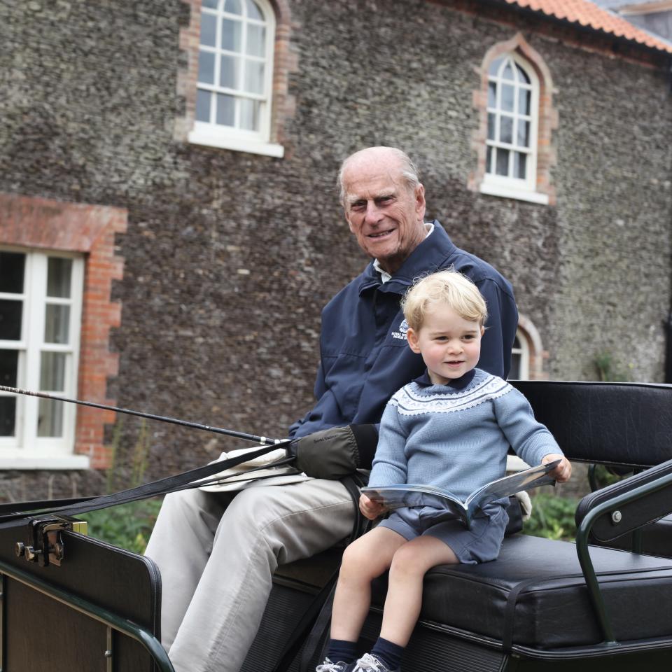 Prince Philip sits with Prince George in a carriage