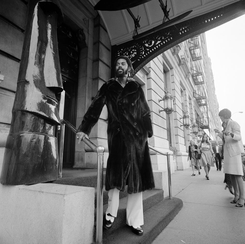 FILE - This Sept. 10, 1974 file photo, basketball player Walt Frazier of the New York Knicks models a black mink fur coat outside Manhattan's Plaza Hotel in New York. The coat was one of a number of mink fashions displayed at the Annual Ben Kahn Fur Collection showing in New York. .Pro player style has been on the upswing for the past decade, especially since the NBA initiated a dress code in 2005, according to observers. Back in the 1970s, players such as Walt “Clyde” Frazier and Julius “Dr. J” Irving prided themselves on their flashy looks. Now, Frazier says his style is as much a part of his persona as the legends of his playing days. (AP Photo/Suzanne Vlamis)