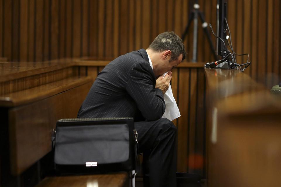 Olympic and Paralympic track star Oscar Pistorius blows his nose in the dock during his trial for the murder of his girlfriend Reeva Steenkamp, at the North Gauteng High Court in Pretoria, March 10, 2014. Pistorius is on trial for murdering his girlfriend Reeva Steenkamp at his suburban Pretoria home on Valentine's Day last year. He says he mistook her for an intruder. "Blade Runner" Pistorius broke down on Monday when the South African court heard details from the autopsy of Steenkamp. REUTERS/Siphiwe Sibeko (SOUTH AFRICA - Tags: CRIME LAW ENTERTAINMENT SPORT ATHLETICS)