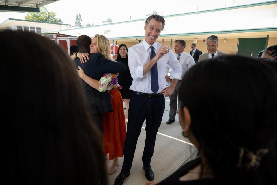 California First Partner Jennifer Siebel Newsom hugs state Superintendent of Public Instruction Tony Thurmond as Gov. Gavin Newsom talks with students at River City High School in West Sacramento on Thursday. Paul Kitagaki Jr./pkitagaki@sacbee.com