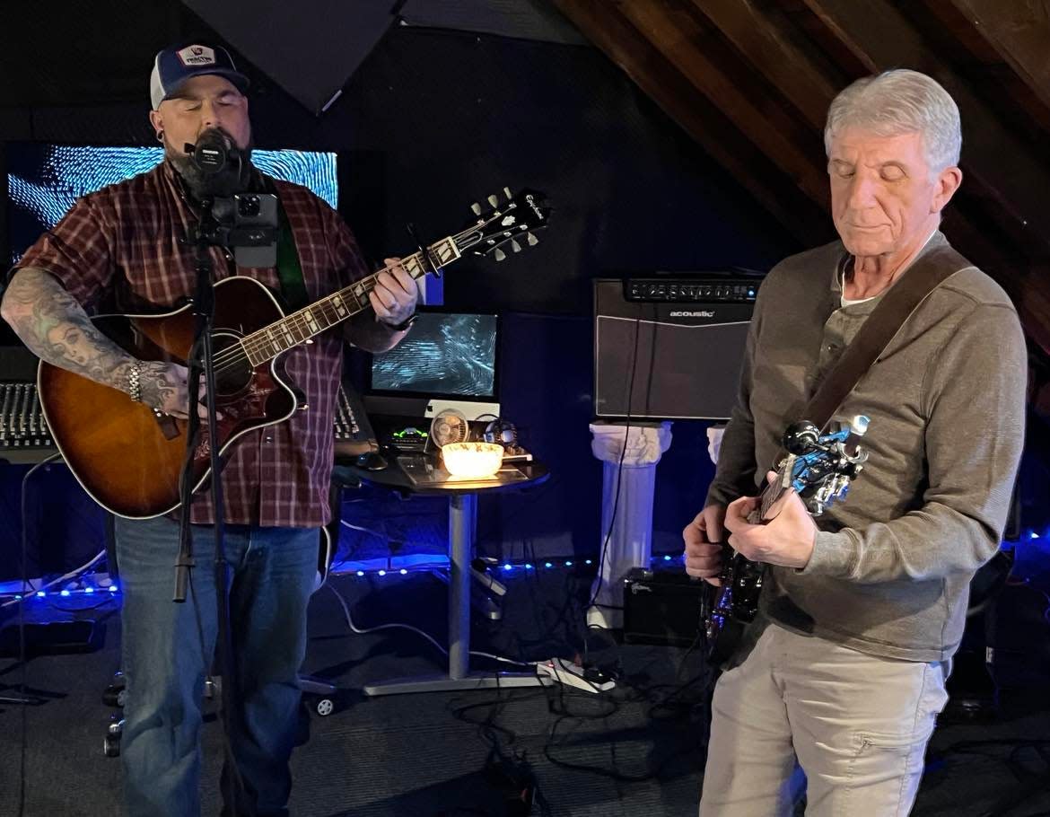 Aaron Hymes, at the microphone, rehearses recently with his band at his Paris Township home. Hymes, also an associate pastor for an East Canton area church, is shown with guitarist Dave Krajcik.