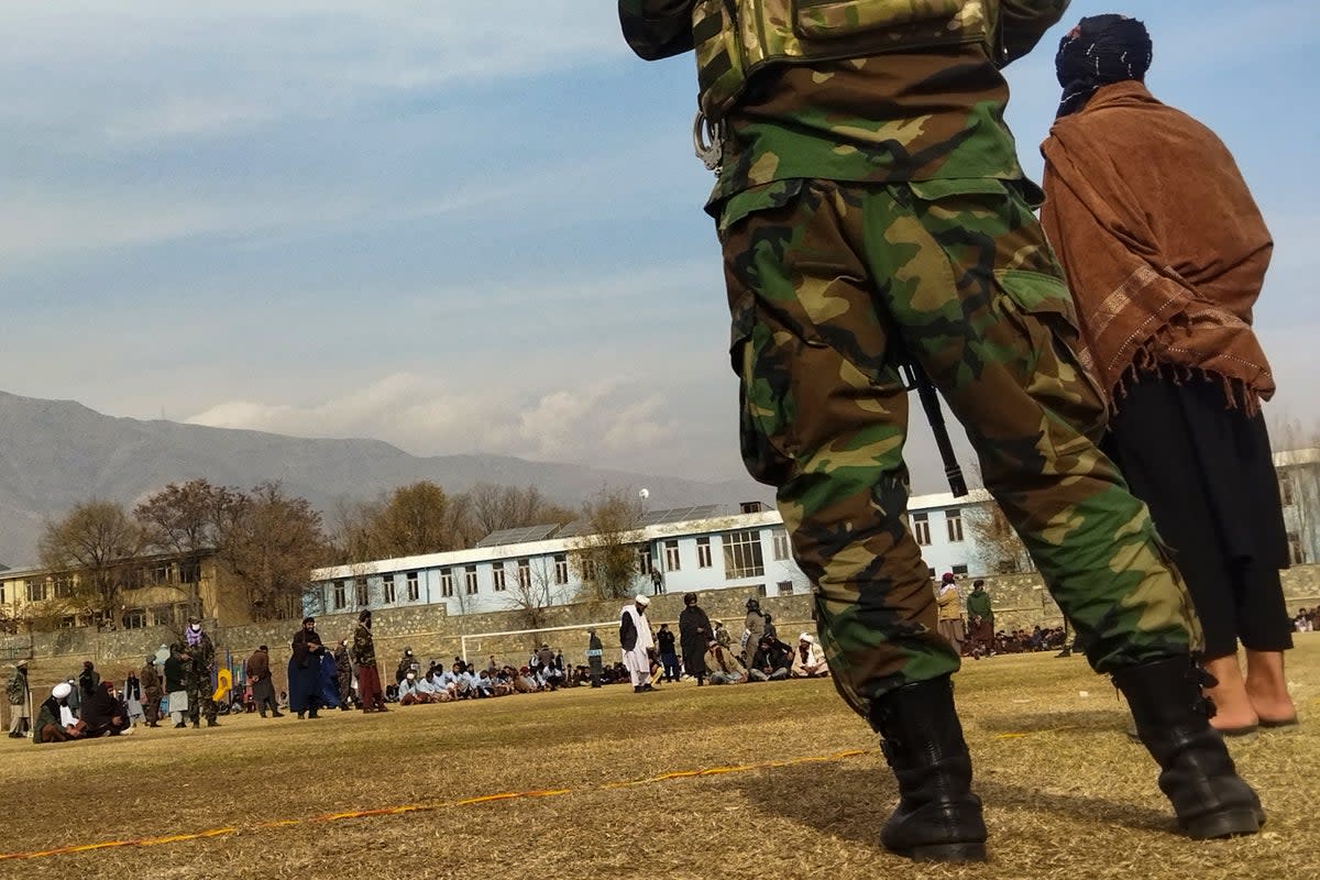 Taliban security personnel keep watch ahead of the court flogging of women and men at a football stadium in Charikar city of Parwan province in December 2022  (AFP via Getty Images)