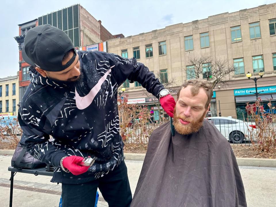 Alfred trims Justin Wilde's beard in downtown Hamilton.