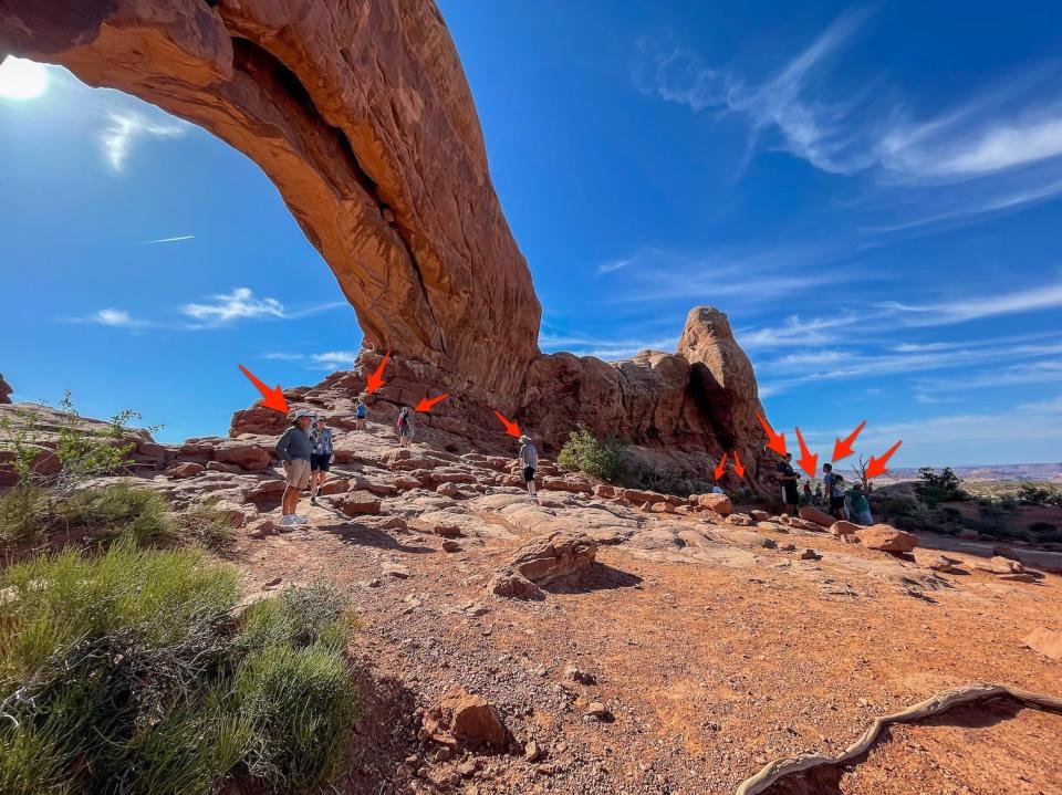 Arrows point to all the people at the windows section of Arches National Park.