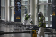 Airport employees disinfect cots, as a preventive measure against the spread of the new coronavirus, to be made available for travelers whose flights are delayed or canceled, at the El Dorado International Airport, in Bogota, Colombia, Saturday, March 21, 2020. (AP Photo/Ivan Valencia)