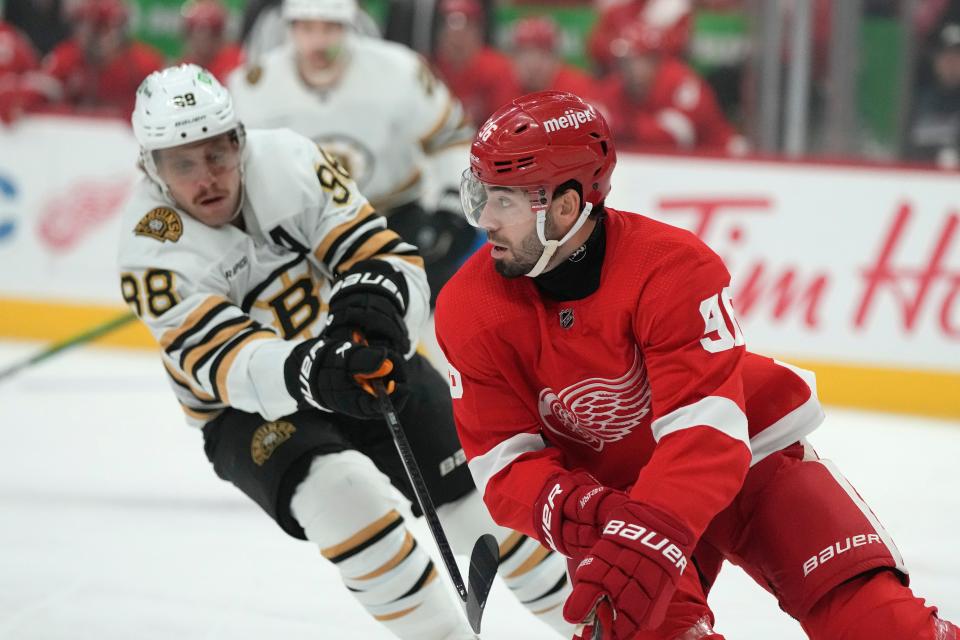 Detroit Red Wings defenseman Jake Walman (96) controls the puck next to Boston Bruins right wing David Pastrnak during the first period at Little Caesars Arena in Detroit on Saturday, Nov. 4, 2023.