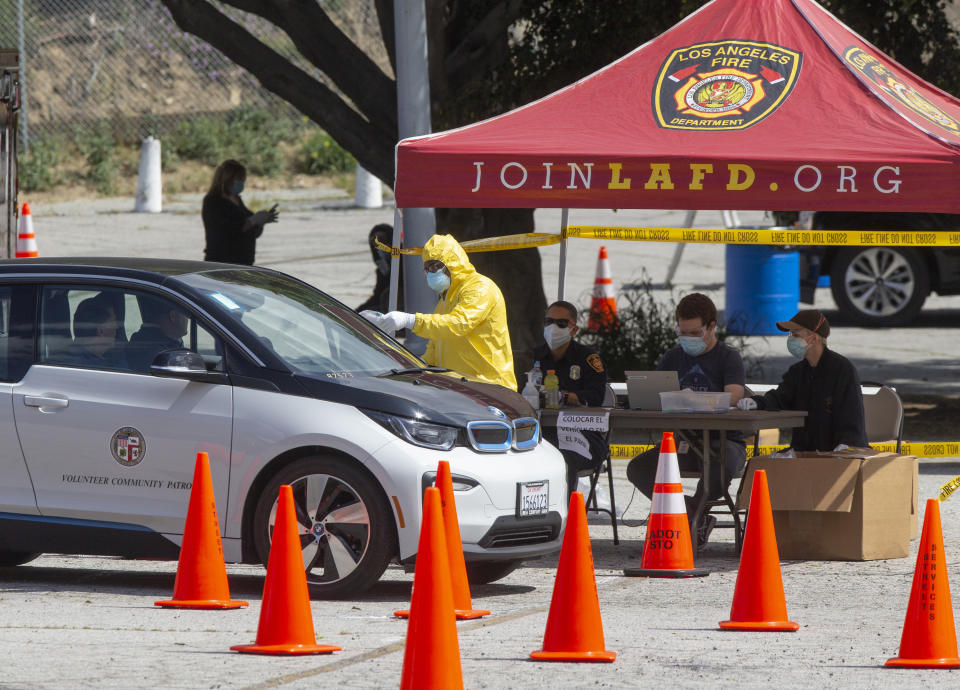 First responders who were scheduled to be tested earlier for COVID-19, get test kits at a drive-up testing site in Elysian Park, Los Angelas Thursday, April 2, 2020. Officials say hand-washing and keeping a safe social distance are priorities in battling the COVID-19 virus. (AP Photo/Damian Dovarganes)