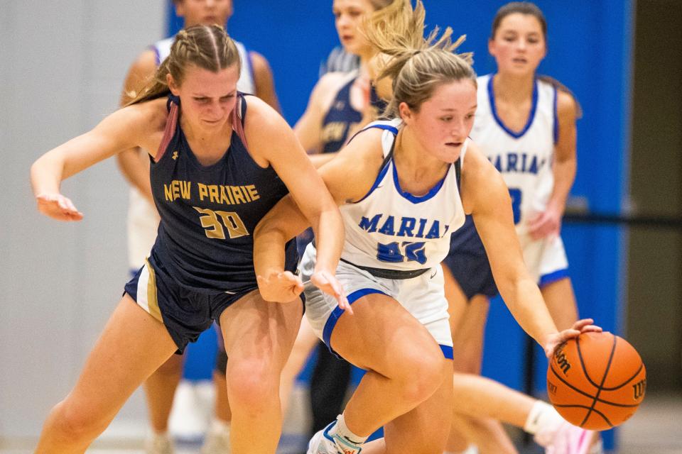 Marian's Aliyah Hershberger (22) gets the ball away from New Prairie's Jaiden Winters (30) during the Marian vs. New Prairie girls sectional basketball game Friday, Feb. 3, 2023 at Marian High School.