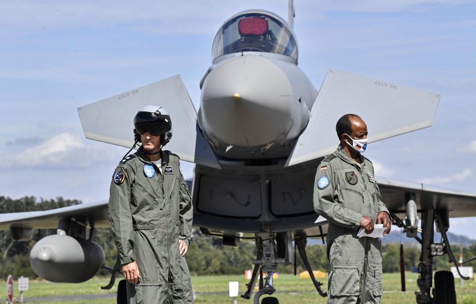 German Lieutenant colonel Samuel Mbassa, right, stands with a pilot from Israel, left, in front of an Eurofighter at the airbase in Noervenich, Germany, Thursday, Aug. 20, 2020. Pilots from Israel and Germany will fly together the next two weeks during the first joint military Air Force exercises between the two nations in Germany. (AP Photo/Martin Meissner)