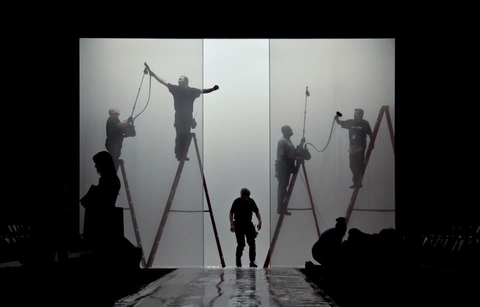 Production crew work on final details on the runway set for the showing of the J. Mendel Spring 2014 collection on Wednesday, Sept. 11, 2013 in New York. (AP Photo/Bebeto Matthews)