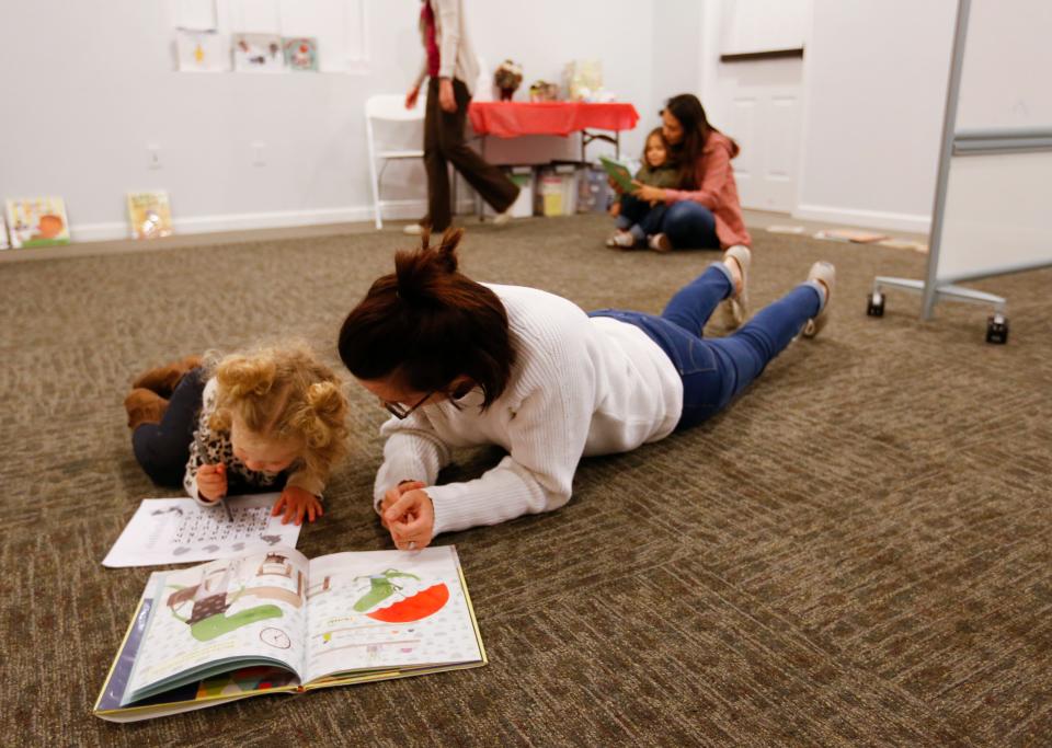 In December 2017, a parent reads to her 2-year-old daughter during a Ujima event at the Bartley-Decatur Neighborhood Center.