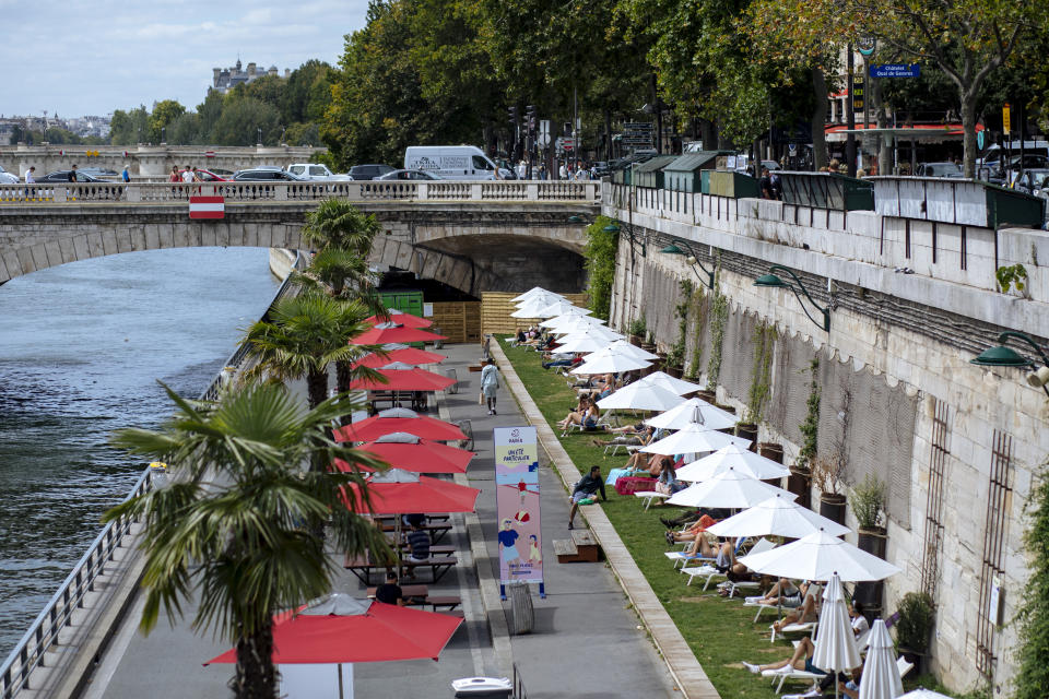 FILE - In this July 28, 2020, file photo, people enjoy the sun on deckchairs along the river Seine in Paris. An outbreak among 18- to 25-year-olds at a seaside resort on the Brittany coast is crystallizing fears that the virus is flaring again in France, on the back of vacationers throwing COVID-19 caution to the summer winds. (AP Photo/Kamil Zihnioglu, File)