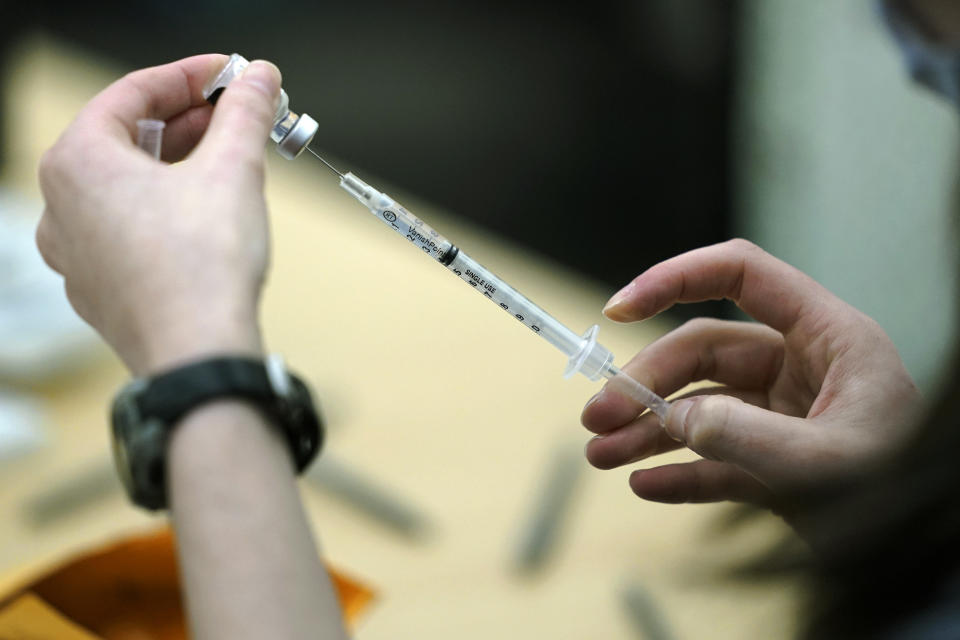 A worker fills a syringe with the Pfizer COVID-19 vaccine at the Yakima Valley Farm Workers Clinic in Toppenish, Wash., Thursday, March 25, 2021. In Washington state, workers who labor in crowded conditions such as meatpacking facilities and farms and orchards became eligible for the vaccine earlier in the month. (AP Photo/Ted S. Warren)