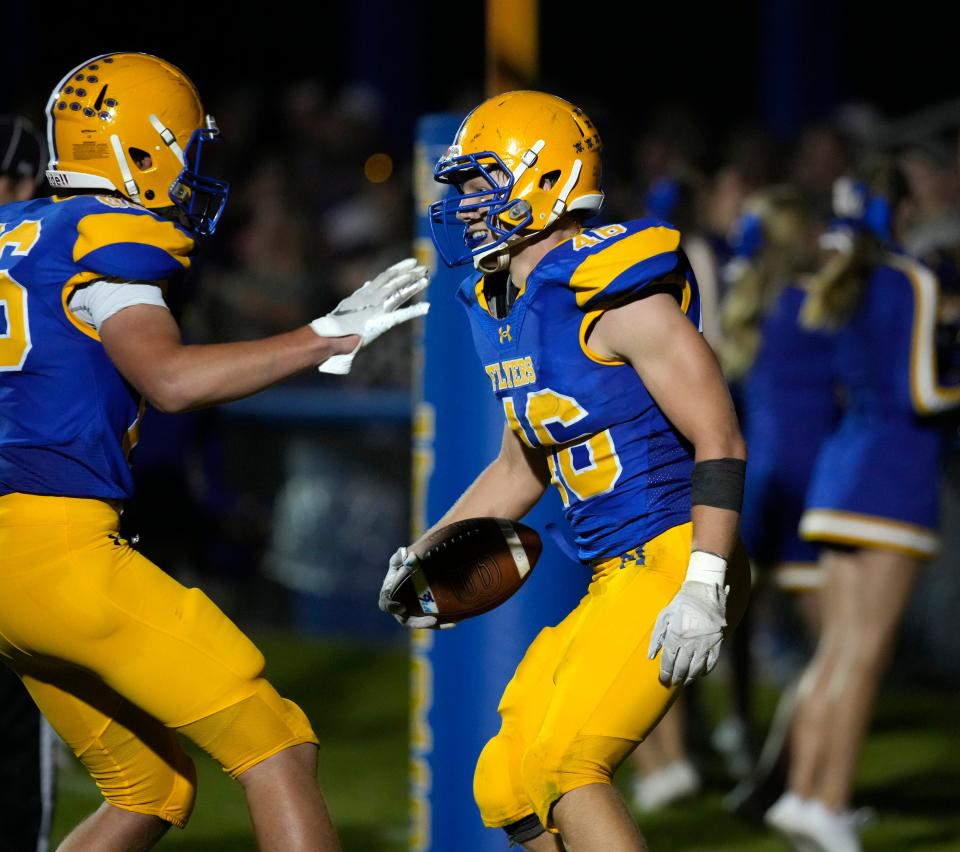 Marion Local's Ethan Heitkamp (46) celebrates with Oliver Huelsman (86) during a 14-13 win over Versailles on Sept. 22.