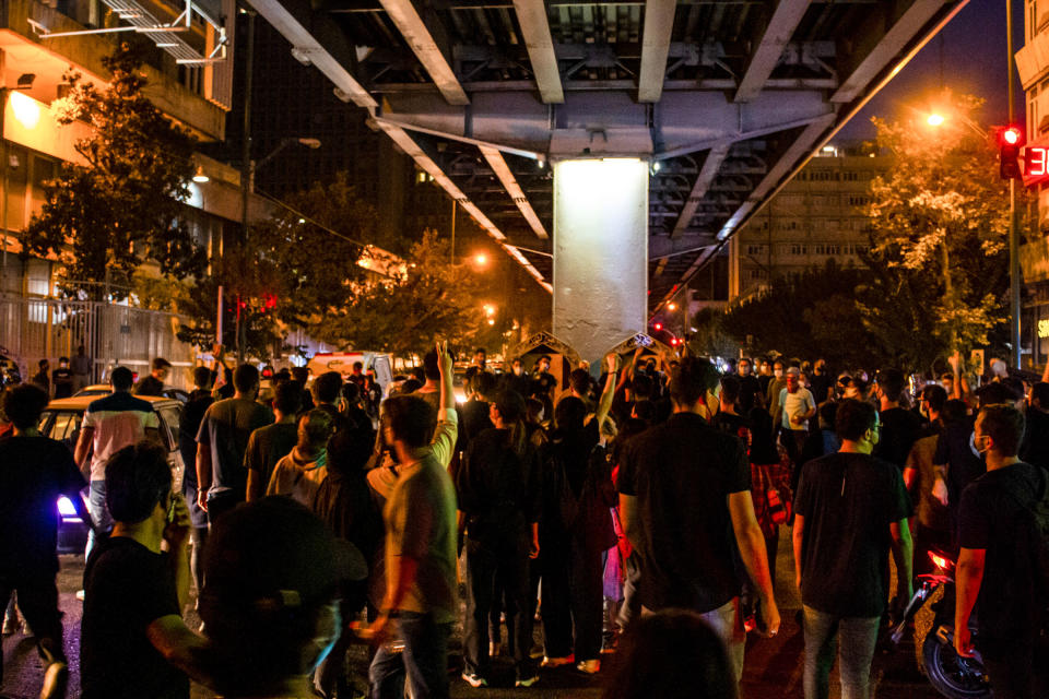 People gather during a protest for Mahsa Amini, who died after being arrested by morality police allegedly not complying with strict dress code in Tehran