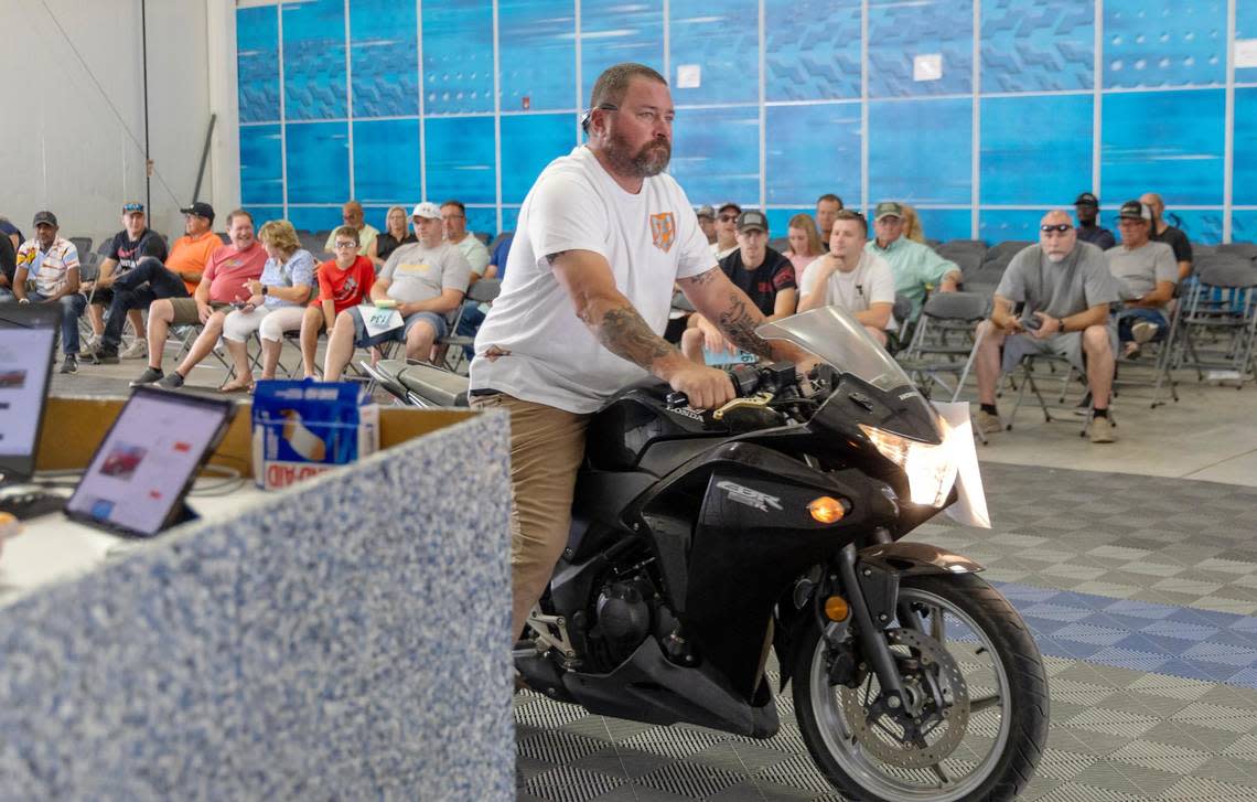 A motorcycle is driven through the building as it goes up for sale at the auction.