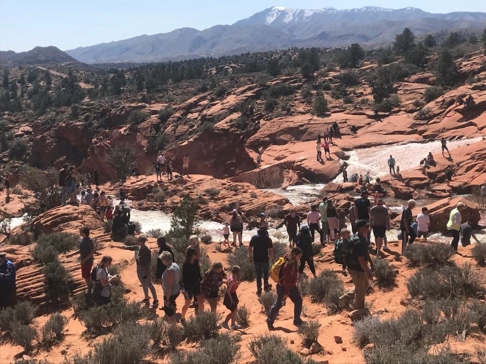 Visitors swarm the raging waters beneath Gunlock Reservoir. Rains in early March filled the reservoir to capacity, sending waterfalls over the dam in a rare spectacle that officials said could bring thousands of visitors throughout the Spring.