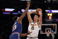 Denver Nuggets center Nikola Jokic (15) looks to pass around New York Knicks center Mitchell Robinson during the first half of an NBA basketball game Saturday, Dec. 4, 2021, in New York. (AP Photo/Adam Hunger)